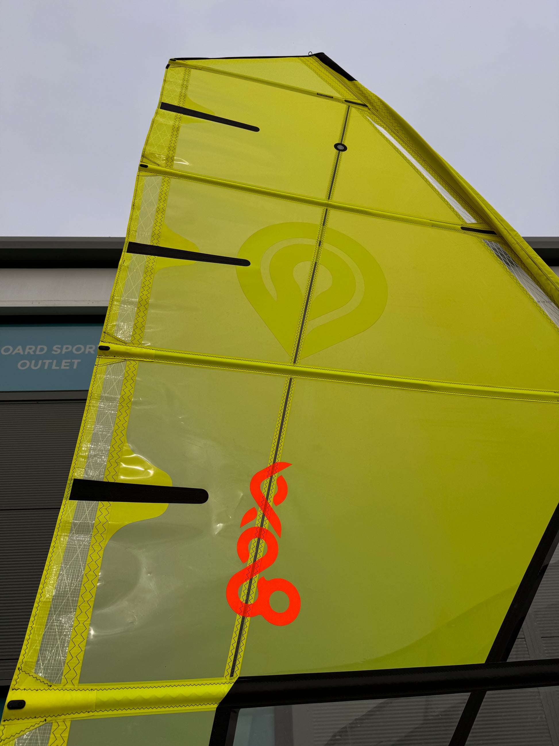 Yellow windsurf Sail with a Surfdoctor logo on a building