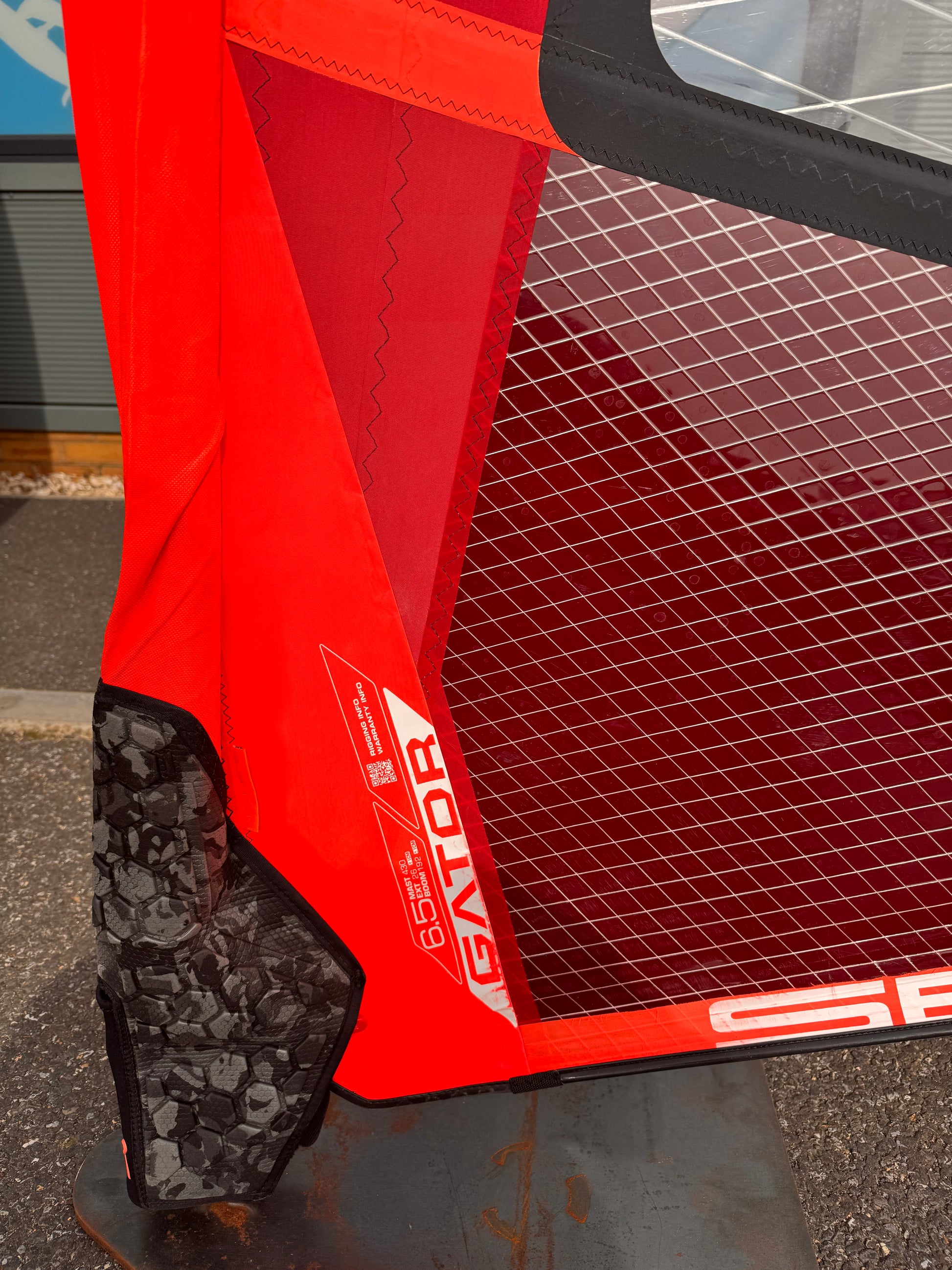 Close-up of a red and black sports equipment bag with visible branding.
